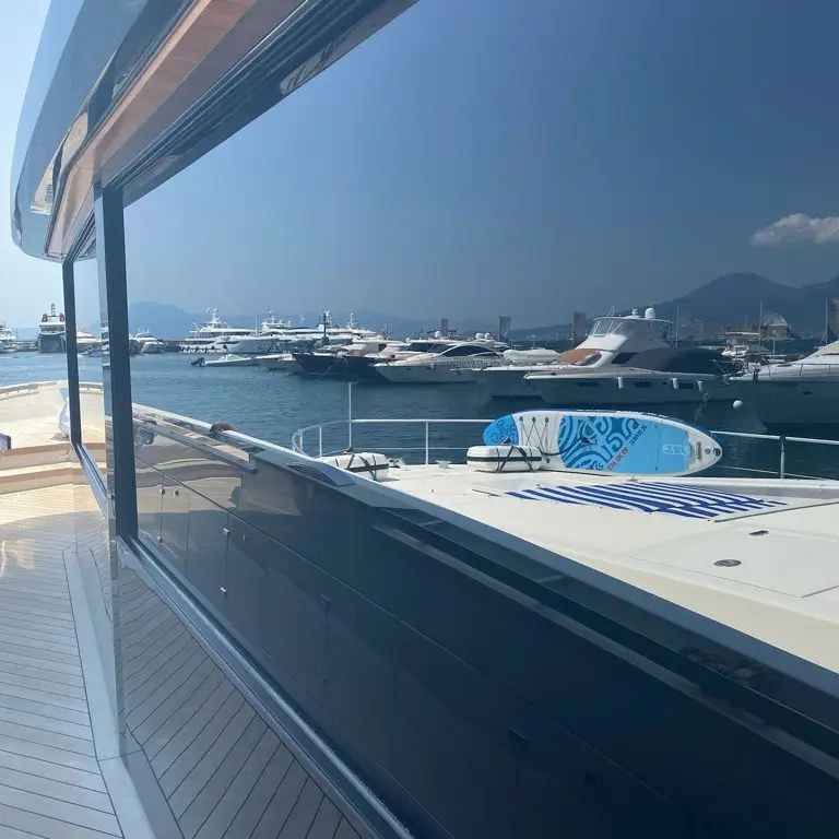 Vista laterale di uno yacht di lusso ormeggiato in porto con grandi superfici vetrate oscurate, ideale per privacy, controllo solare e comfort visivo a bordo in ambito nautico.